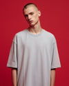 Man wearing a plain gray t-shirt against a red background