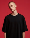 Person wearing a black t-shirt against a red background