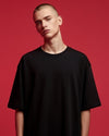 Person wearing a black t-shirt against a red background
