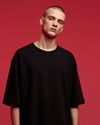 Person wearing a black t-shirt against a red background