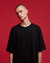Person wearing a black t-shirt against a red background
