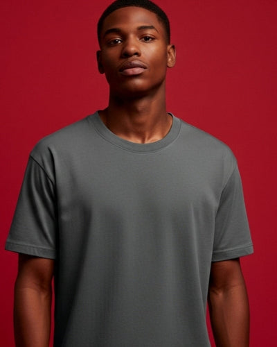 Man wearing a gray t-shirt against a red background