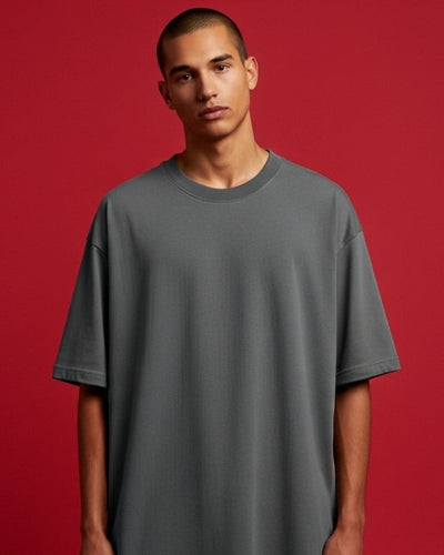 Man wearing a gray t-shirt against a red background