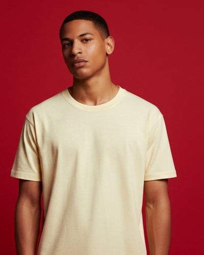 Man wearing a beige t-shirt against a red background
