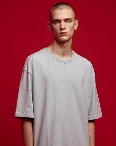 Man wearing a gray t-shirt against a red background