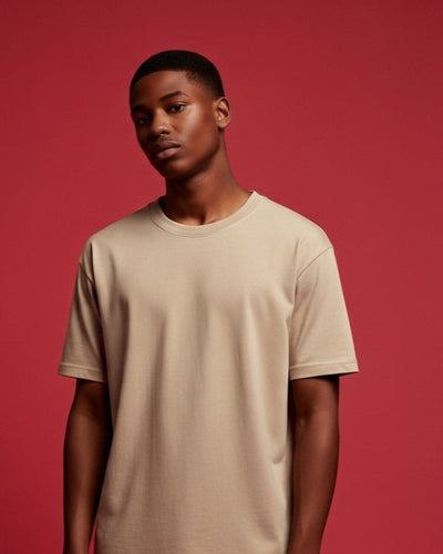 Man wearing a beige t-shirt against a red background