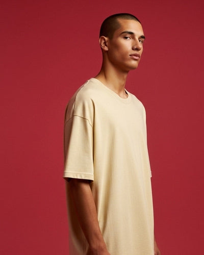 Man wearing a beige t-shirt against a red background