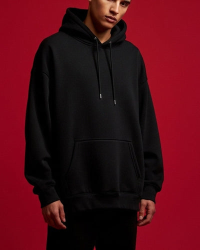 Person wearing a black hoodie against a red background