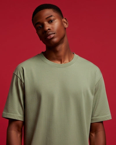 Man wearing a light green t-shirt against a red background