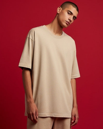 Man wearing a beige outfit against a red background
